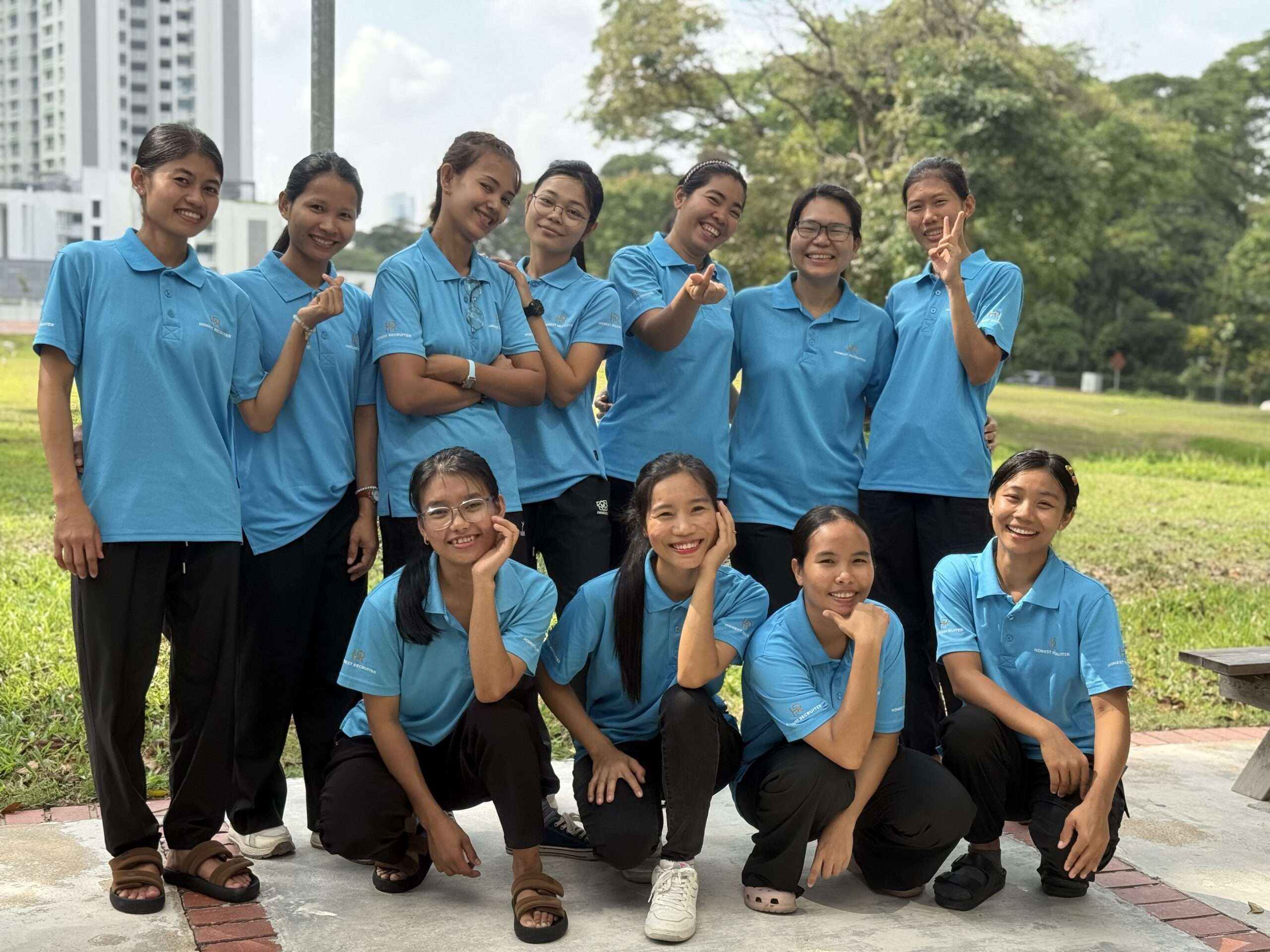 Honest Recruiter Domestic Helper Training Team in Singapore - Honest Recruiter Singapore Group of smiling domestic helpers in blue uniforms during Honest Recruiter training session in Singapore