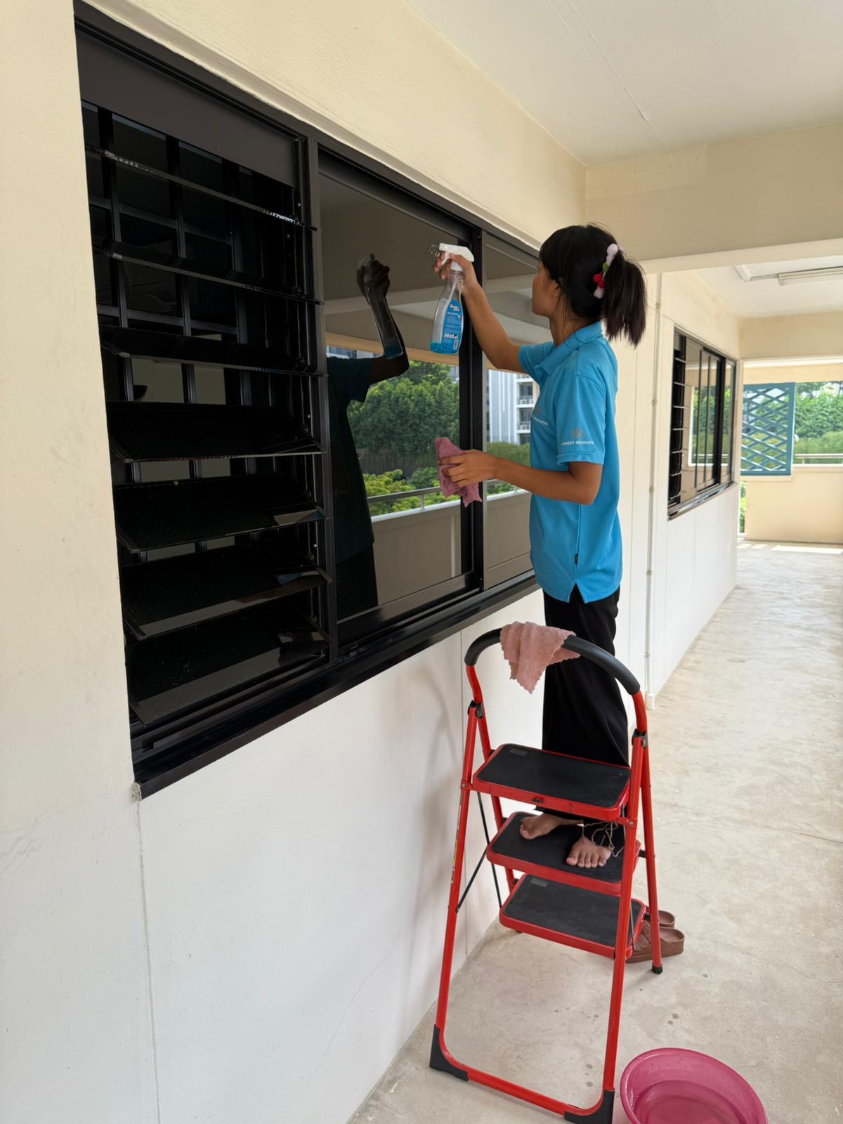 Honest Recruiter cleaner wiping bedroom window grille during home cleaning service in Singapore.